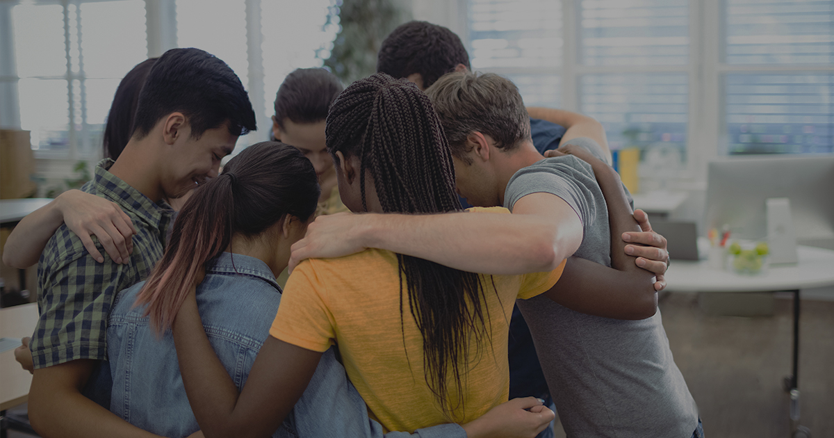 A diverse group of people in an encouraging huddle